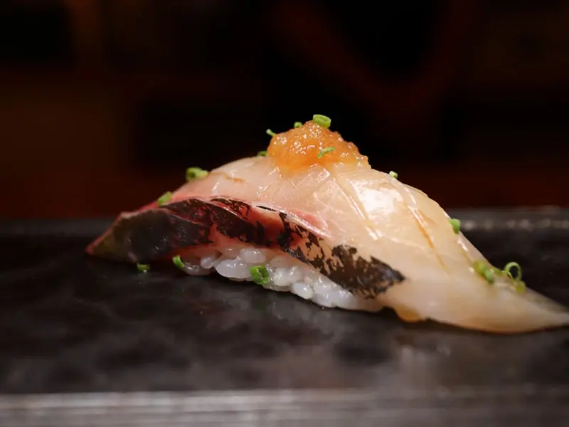 Hamachi nigiri topped with tobiko crunch at Umami Crudo , a Japanese Restaurant in Boston